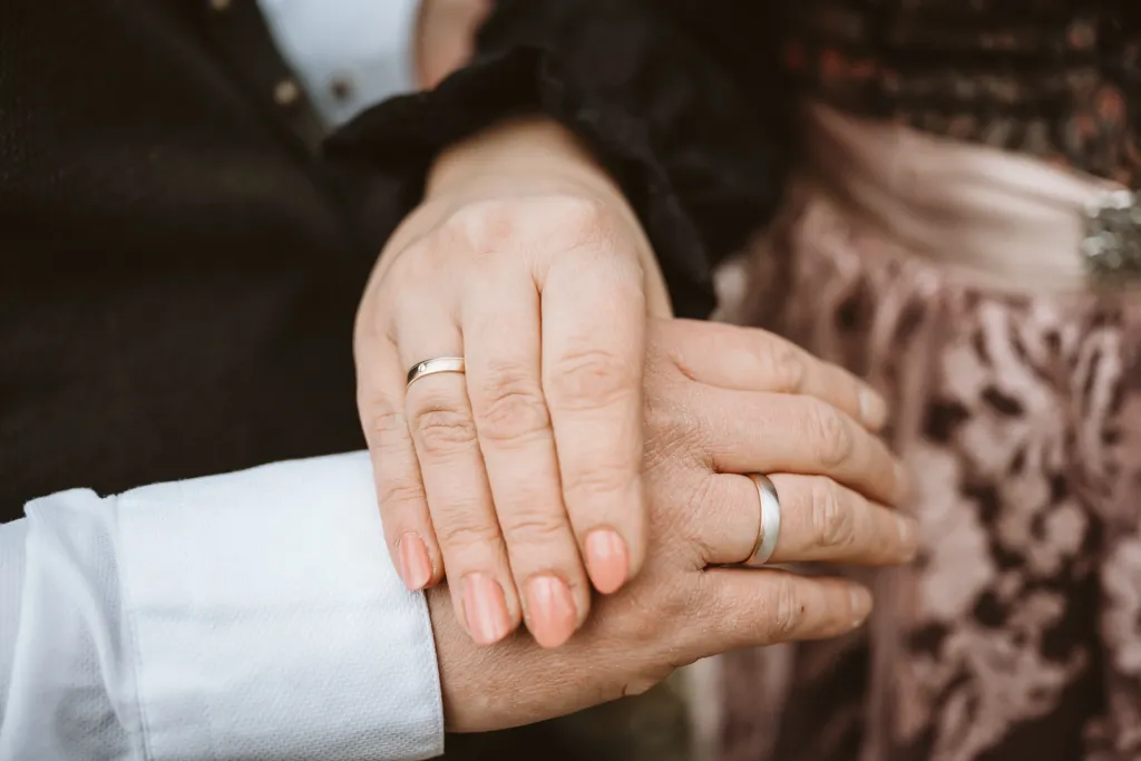 Das Zeichen der Liebe: Hände und Ringe des Brautpaars. Detailaufnahme der Hände des Brautpaars mit Eheringen.