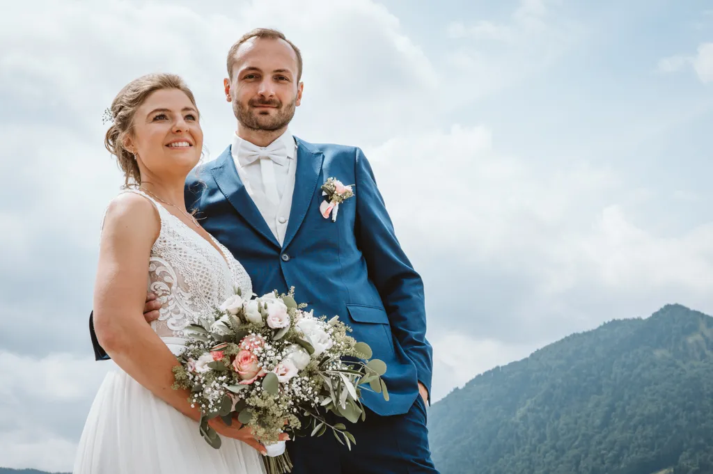 Beeindruckendes Brautpaar-Foto vor einer Bergspitze am Tegernsee. Ich begleite Hochzeiten in ganz Bayern, um diese unvergesslichen Momente für Sie einzufangen.